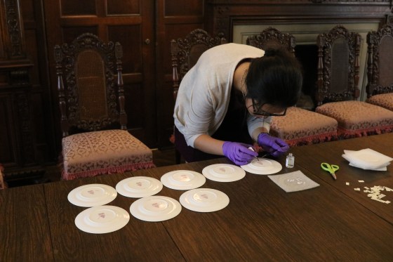 Desai, applying removable adhesive on Booths’ saucers to attach inventory numbers.