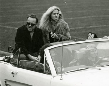 Homecoming Queen Barbara Tiso takes a convertible ride around the field with Academy President Wallace Mitchell.