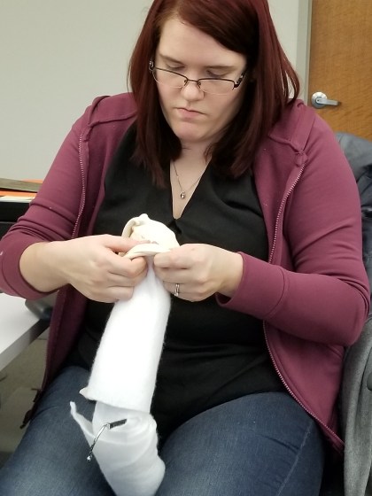 Volunteer Kate Nummer assembles museum-quality padded hanger. She recommends buying the preassembled one in the next round of rehousing.