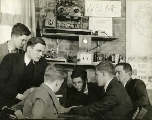 Boys sit around a ham radio.