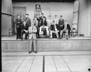 Group of boys sitting on a stage.