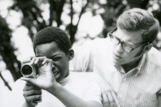 student holding camera with teacher